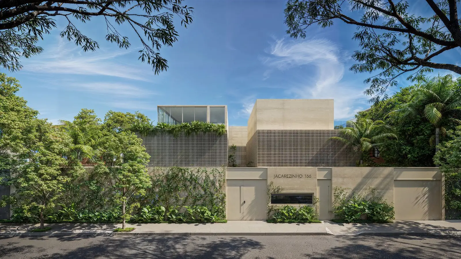 Fachada das três casas, com jardim vertical no muro de cobogó e a inscrição Jacarezinho 166