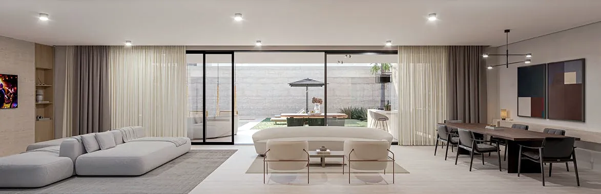 Spacious living room with light sofas, dining table and frames opening onto the garden