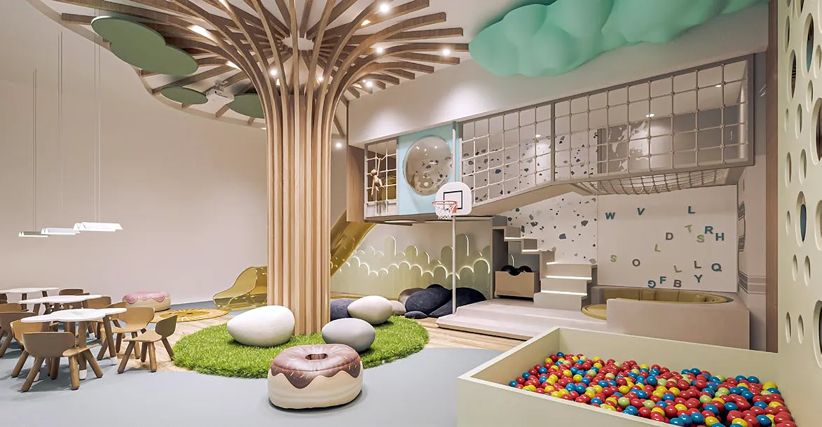 Playroom with a sculptural wooden tree, ball pit and climbing wall