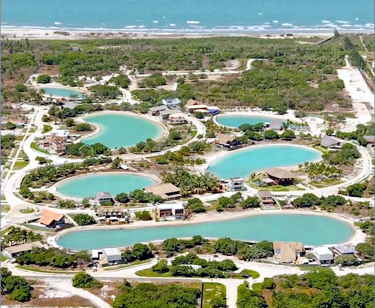 Vista aérea do Vila Carnaúba, com lagoas de água doce entre a vegetação nativa e o mar ao fundo